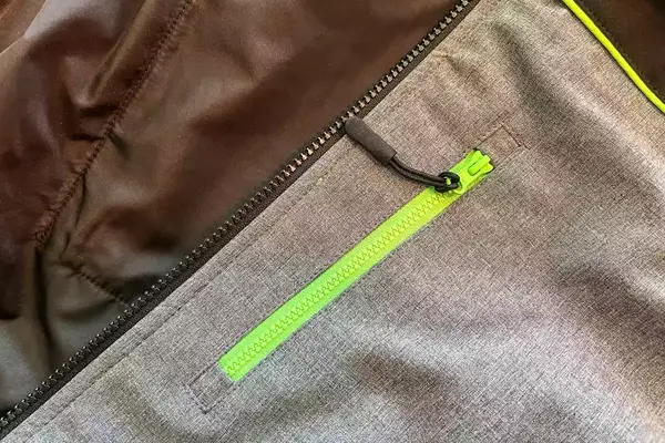 A close-up of the closed zipper of the pocket of the Conqueco Men