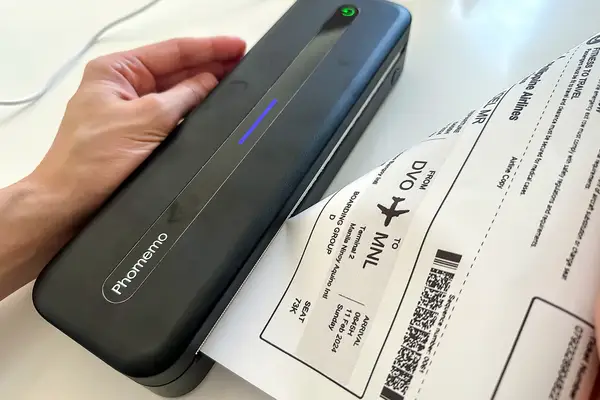 A compact printer with a boarding pass being processed