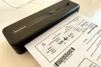 A portable document scanner printing a ticketlike paper