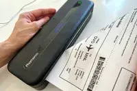 A compact printer with a boarding pass being processed