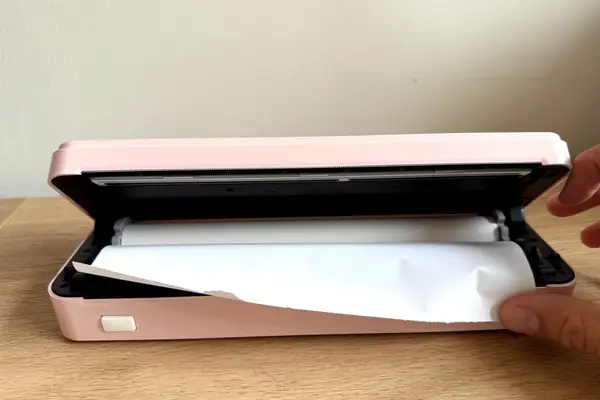 A hand interacting with JADENS Bluetooth Thermal Printer exposing the paper roll inside