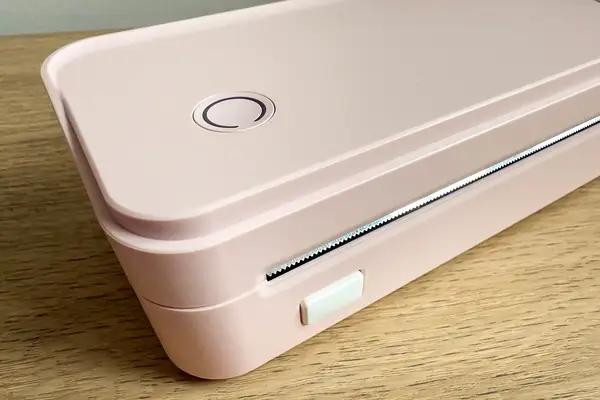 JADENS Bluetooth Thermal Printer placed on a wooden surface features a button 