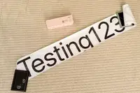 JADENS Bluetooth Thermal Printer with a sample printout saying Testing123 placed on a textured surface