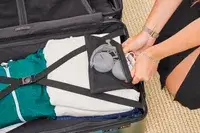 A person packs the Calpak Hue Trunk Luggage