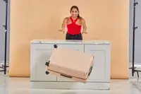 Person pushing the July Checked Plus Large Luggage off a counter