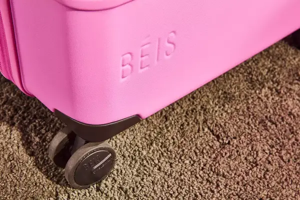 Person pulling a Samsonite Winfield 2 Hardside Luggage With Spinner Wheels over rocks