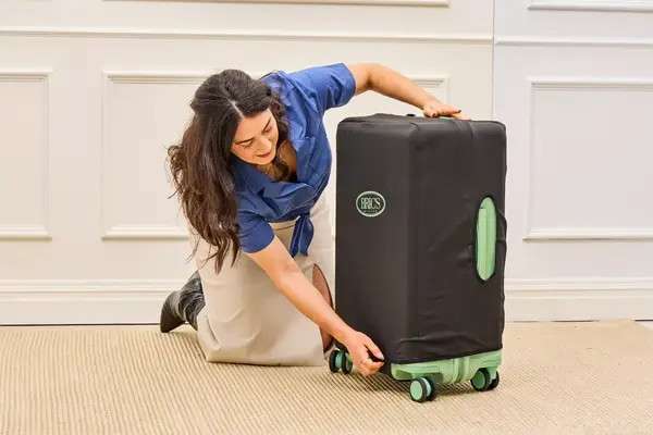 A person places a cover on the Positano Expandable 27-inch Spinner