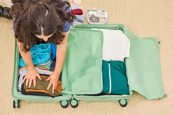 A person packs the Positano Expandable 27-inch Spinner