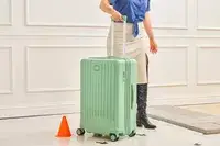 A person wheels the Positano Expandable 27-inch Spinner over the floor