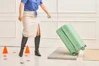 A person rolls the Positano Expandable 27-inch Spinner over stone