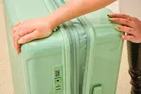 A person closes the Positano Expandable 27-inch Spinner