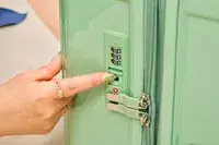 A person points to the lock on the Positano Expandable 27-inch Spinner