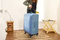 A person weighs the Travelpro VersaPack+ Large Check-In
