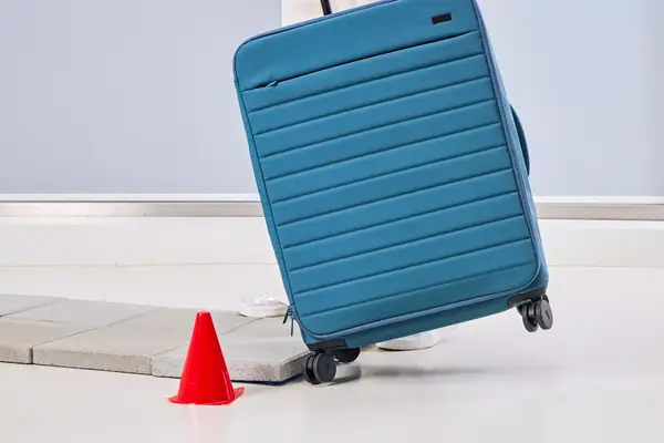 A person rolls the Away The Softside Large over stone pavers