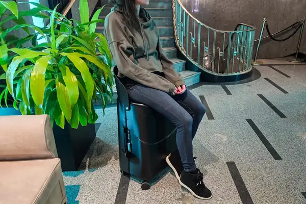 A person sitting on the MiaMily Check In suitcase