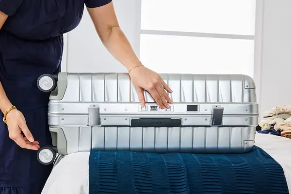 A person locks the Samsonite Proxis ALU Large Spinner