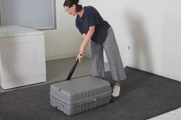 Person hitting the Beis 29-Inch Large Check-in Roller with a baseball bat