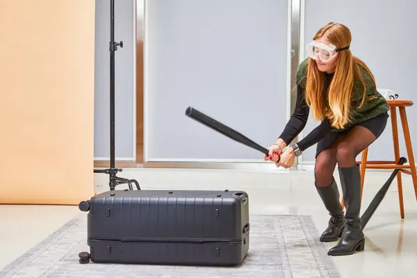 Person zipping the Beis 29-Inch Large Check-in Roller on a table