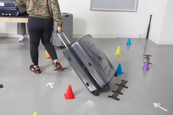 A person hitting the Travelpro Maxlite Air Medium Check-In Hardside Spinner with a bat