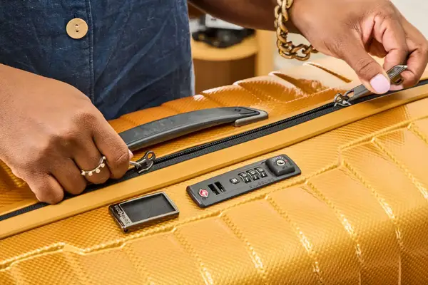 A person unzips the Samsonite Proxis Medium Spinner