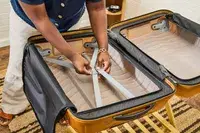 A person adjusts the straps on the inside of the Samsonite Proxis Medium Spinner