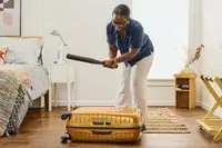 A person hits the Samsonite Proxis Medium Spinner with a baseball bat