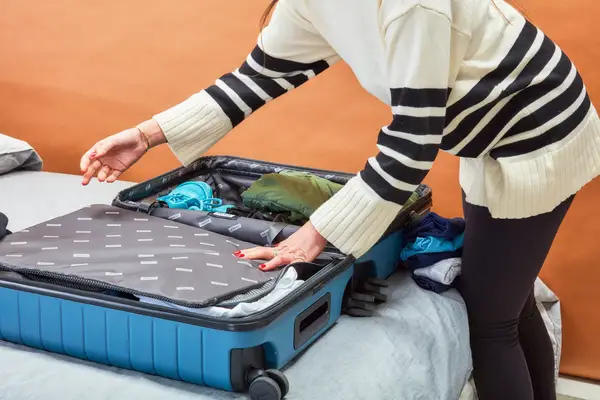 A person packing the Away Medium suitcase