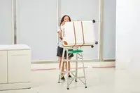 A person pushing the Delsey Paris Chatelet Air 2.0 28 Inch Large Checked Spinner off of a ladder