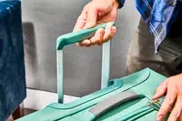 Hand pulling up the handle in the Samsonite Elevation Plus Large Softside Spinner