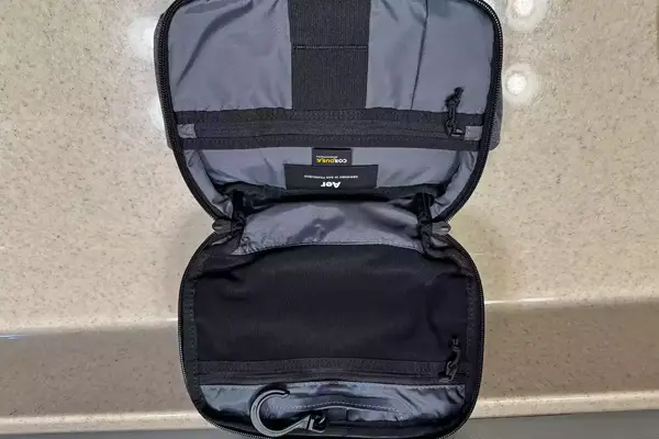 The Aer Travel Kit 2 unzipped and opened on a counter