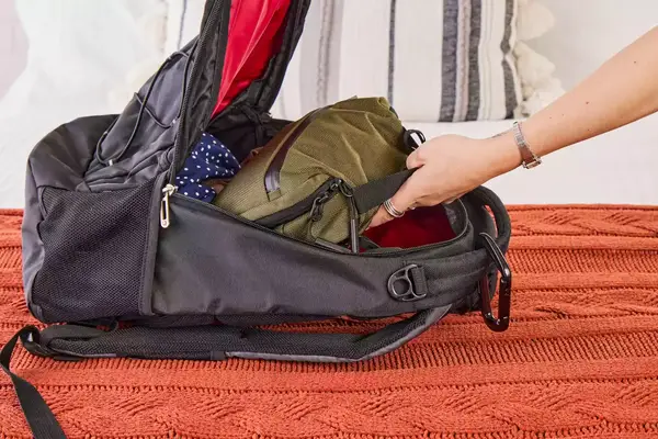 A person places the Aer Travel Kit 2 into a backpack