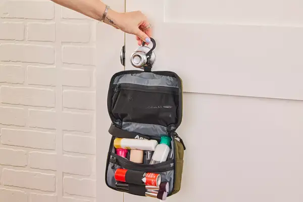 A person hangs the Aer Travel Kit 2 on a doorknob