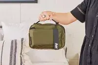 A person holds up the Aer Travel Kit 2 by the top handle