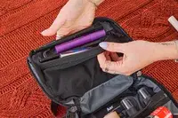 A person places travel items into the Aer Travel Kit 2