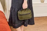 A person holds the Aer Travel Kit 2 by the top handle