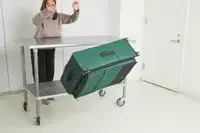 A person throws the Antler Soft Stripe Lightest Large Luggage off of a wheeled cart