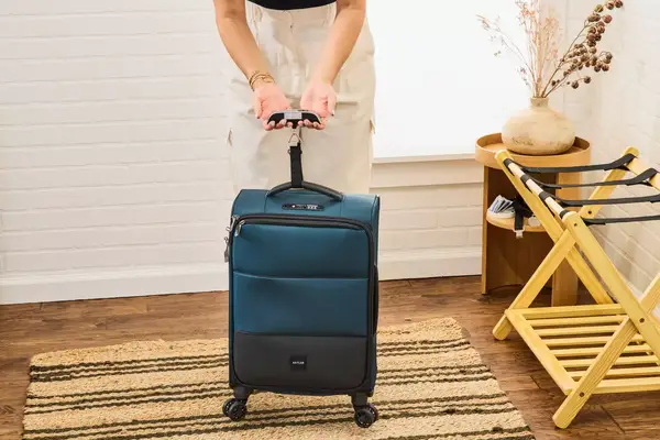 A person weighs the Antler Soft Stripe Carry-On