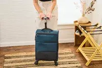 A person weighs the Antler Soft Stripe Carry-On