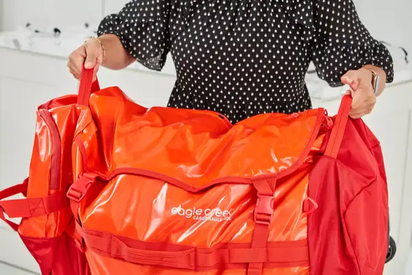 A person wheels the Samsonite Uplift Hardside Carry-on over carpet