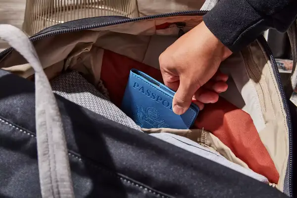 Hand putting a passport in the Bellroy Classic Weekender 45L