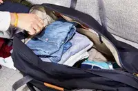 Hand packing clothes into the Bellroy Classic Weekender 45L