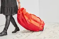 A person weighs the Samsonite Uplift Hardside Carry-on