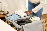 A person packs the Samsonite Uplift Hardside Carry-on