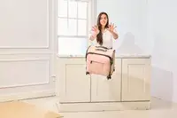 A person pushing the Calpak Luka Soft-sided Mini Carry-on Luggage off a counter