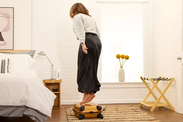 A person jumps on top of the Samsonite Proxis Global Carry-On Spinner