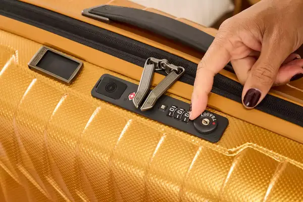 A person sets the lock on the Samsonite Proxis Global Carry-On Spinner