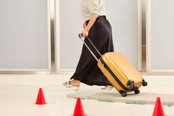 A person wheeling the Samsonite Proxis Global Carry-On Spinner on a tiled platform