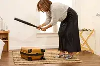 A person hits the Samsonite Proxis Global Carry-On Spinner with a baseball bat