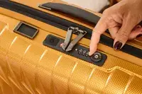 A person sets the lock on the Samsonite Proxis Global Carry-On Spinner