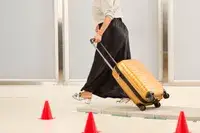 A person wheeling the Samsonite Proxis Global Carry-On Spinner on a tiled platform
